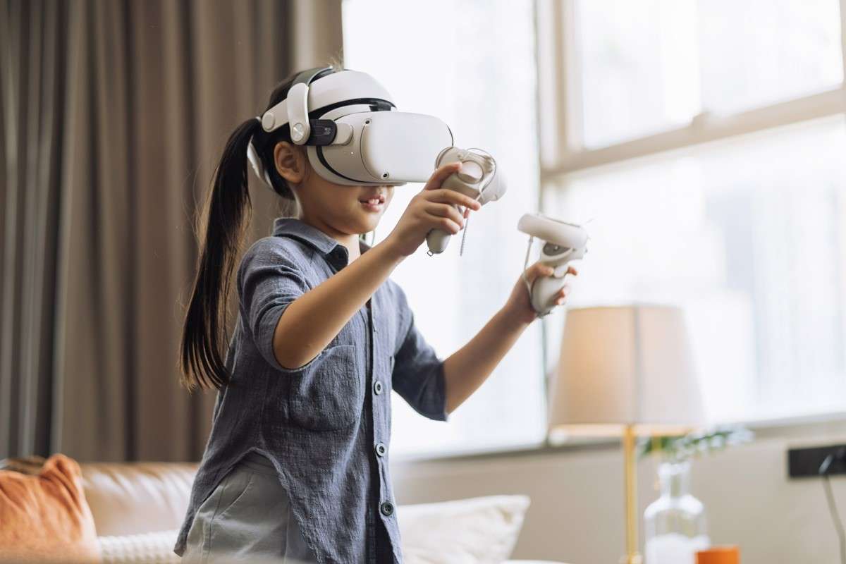 exiting-asian-child-female-enjoy-metaverse-gaming-with-wearable-vr-headset-with-control-handle-playing-sport-gaming-online-living-room-homehome-technology-female-