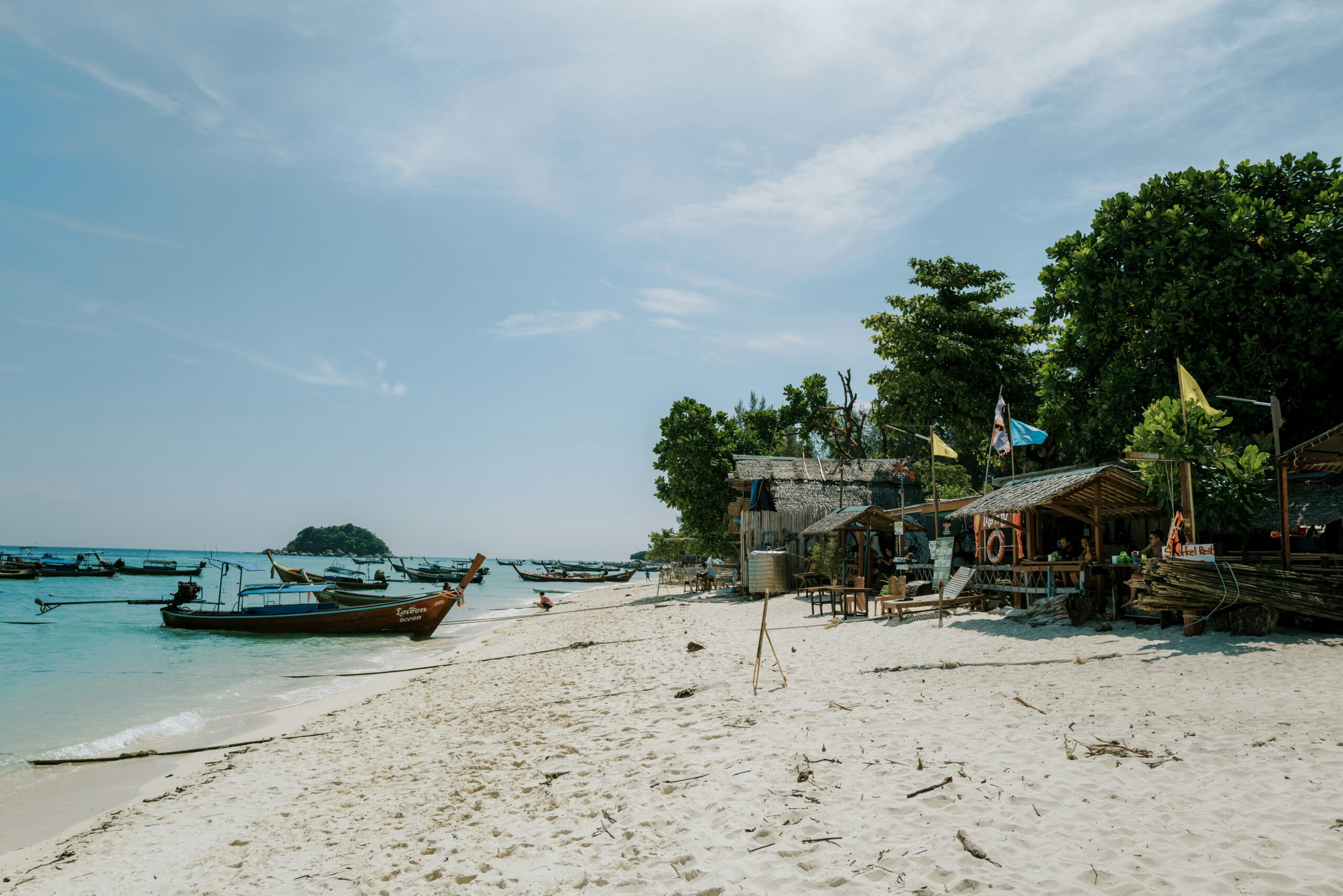 a beach with boats and people on it